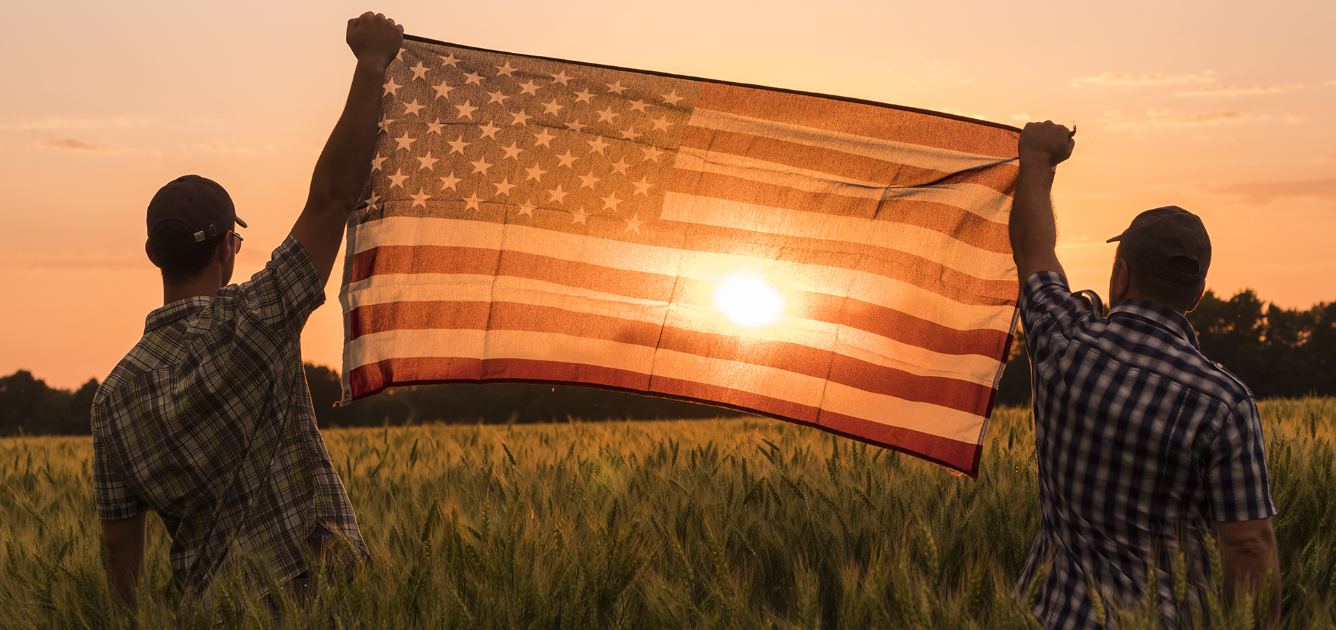 two men holding American Flag up